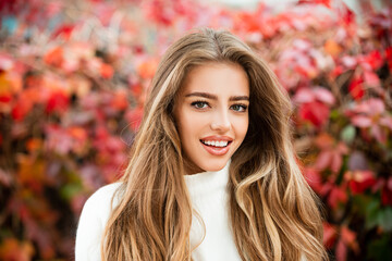 Happy autumn woman having fun with leaves outdoor in park.