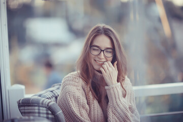 happy girl autumn cafe sweater concept vision model with glasses posing