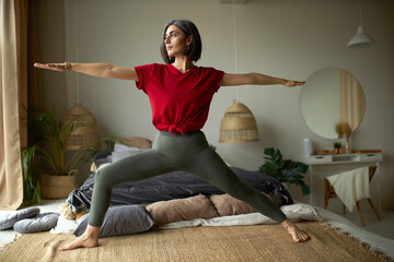 People, activity, health and vitality concept. Stylish barefoot young woman exercising at home,...