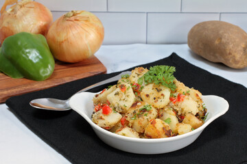 Home fried potatoes with parsley, peppers and onions in a white casserole.