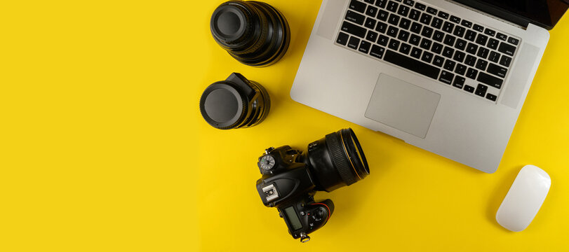 Photographer's equipment.Flat lay composition with photographer's equipment and laptop on yellow background