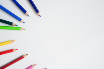 The cropped shot view of color pencils with white background, blank copy space screen for your text message or information content.