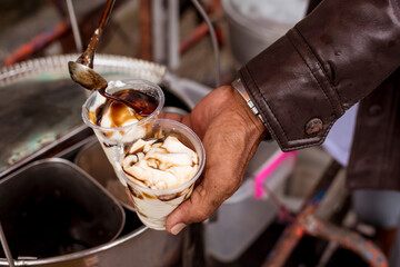 Adding extra sugar syrup to 2 cups of Taho. Taho is a Philippine snack made of soft tofu,...