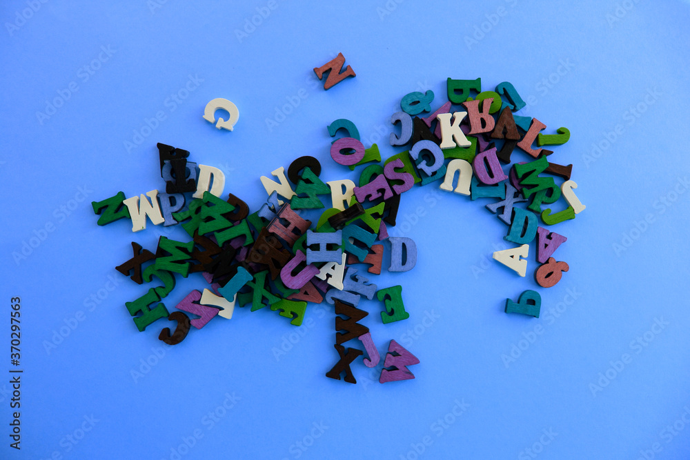 Fototapete the letters of the alphabet are scattered randomly on a blue background. beautiful color font.