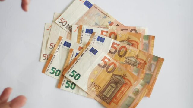 White caucasian womans hands collecting euro money from table