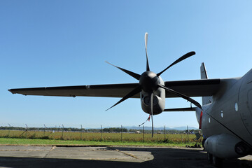 A close-up of a propeller with six blades and a wing of a military aircraft © E-lona