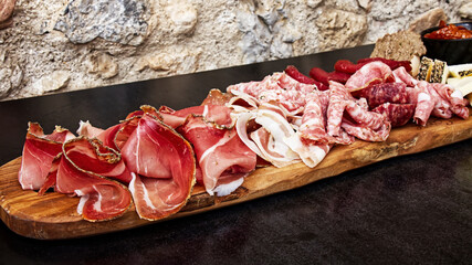 Rustic Tuscan tray with typical products: prosciutto (ham), brawn, finocchiona, crostini, salami,...