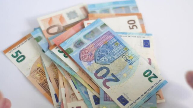 White caucasian womans hands collecting euro money from table