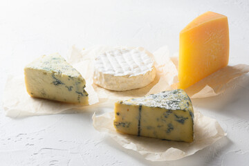 Cheese : yellow Maasdam, white Camembert and blue cheese Dor Blue  on white background. Copy space.  Concept serving cheese.