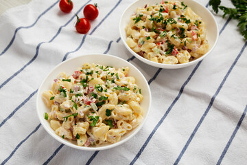 Homemade Macaroni Salad in white bowls, low angle view.