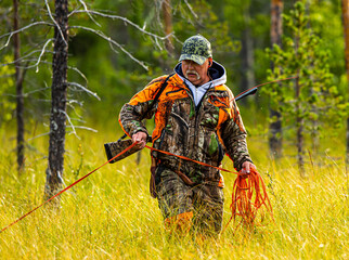 Hunter and hunting dog in the woods summertime