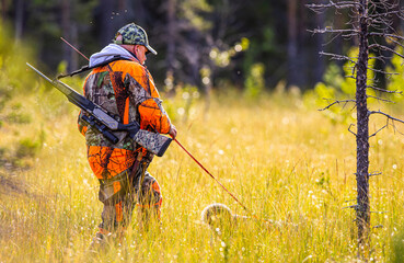 Hunter and hunting dog in the woods summertime