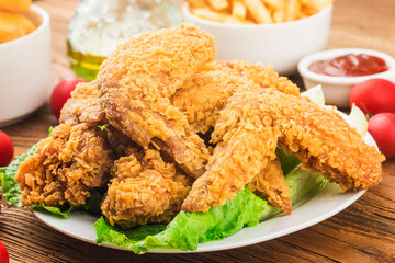 Fried chicken wings on wooden table.