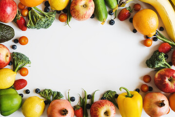 Background with fresh seasonal fruits, vegetables and berries on white table, top view. Plant based diet. Healthy eating