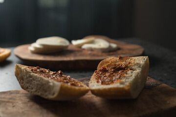 Ciabatta slices with red pesto on olive wood board