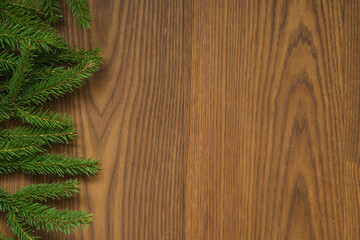 Flat lay christmas background with spruce twigs on ash wood surface