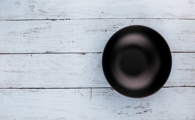 Empty black plate on blue table