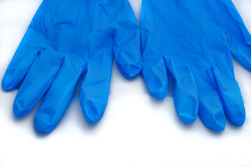 Pair of medical blue latex protective gloves on white background. Protective disposable gloves against the spread of virus, flu, coronavirus (COVID-19), bacterial. Health care and surgical concept.