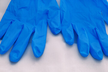 Pair of medical blue latex protective gloves on white background. Protective disposable gloves against the spread of virus, flu, coronavirus (COVID-19), bacterial. Health care and surgical concept.