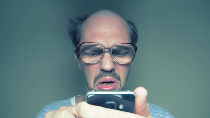 balding man with glasses hardly uses a smartphone. Humor
