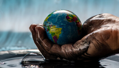 Earth in the shape of a globe in an petroleum stained hand. Concept of eco friendly behavior and...