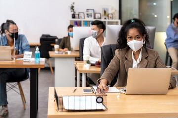 African office worker with asian team in new normal social distance office