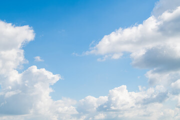 Naklejka na ściany i meble Blue skies on a clear day. White cumulus clouds float across the sky.