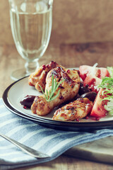 Grilled chicken pieces with fresh salad. Wooden background.	