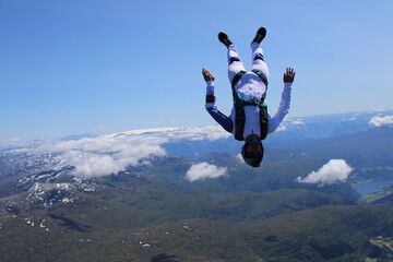 Fototapeta na wymiar Skydivers over snowy mountains in Norway