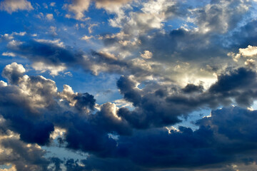 Evening sky with Cumulus clouds and sunset sun