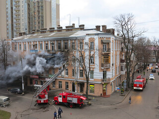 Odessa, Ukraine - December 29, 2016: A fire in apartment building. Strong bright light and clubs, smoke clouds window of their burning house. Firefighters extinguish fire in house. Work on fire stairs