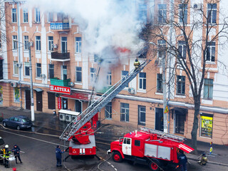 Odessa, Ukraine - December 29, 2016: A fire in apartment building. Strong bright light and clubs, smoke clouds window of their burning house. Firefighters extinguish fire in house. Work on fire stairs