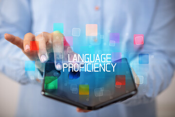 Young man holding a foldable smartphone with LANGUAGE PROFICIENCY inscription, educational concept
