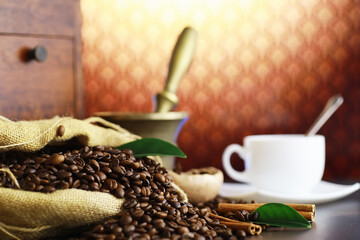 Bag of coffee. Coffee beans roasted on the table. Coffee beans with green leaves for cooking.