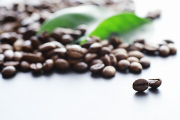 Bag of coffee. Coffee beans roasted on the table. Coffee beans with green leaves for cooking.