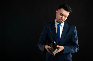 Portrait of business man wearing blue business suit and tie showing empty wallet