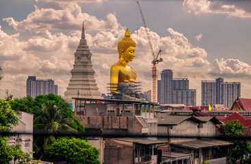 Fototapeta premium Close-up natural background of the waterfront community, a large Buddha statue (Wat Paknam Phasi Charoen) stands beautifully, seen in tourist attractions in Bangkok, Thailand.