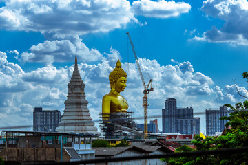 Fototapeta premium Close-up natural background of the waterfront community, a large Buddha statue (Wat Paknam Phasi Charoen) stands beautifully, seen in tourist attractions in Bangkok, Thailand.