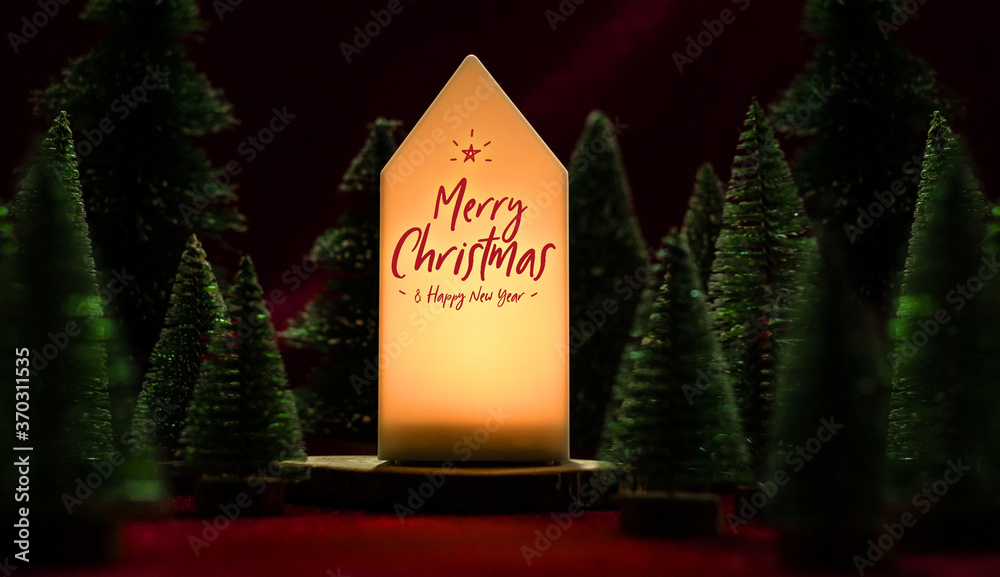 Poster merry christmas and happy new year text on home lamp with xmas tree on red velvet fabric table in da