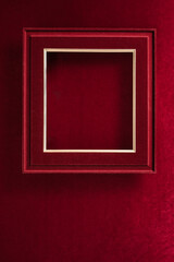 Fototapeta premium Blank Red Christmas felt photo frame on velvet red felt fabric top view winter holiday background