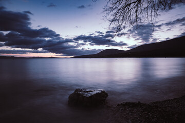 Nightfall on pebble beach at La pointe du grain, Neuchâtel, Switzerland