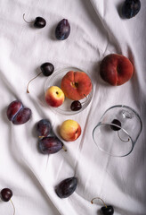nectarines and plums with cherries on a fabric tablecloth
