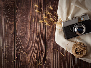 Bodegón en mesa de madera con cámara fotográfica clásica.