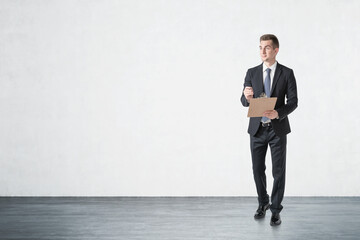 Young businessman with clipboard, mock up