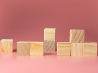 Empty wooden cube on a pink background. For new ideas to be put into the picture.Rear focus.