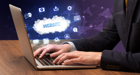 Businessman working on laptop with WEBSITE inscription, modern technology concept