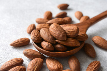 Baked Almond in wooden spoon on gray background,copy space.
