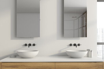 Two round sinks in white bathroom