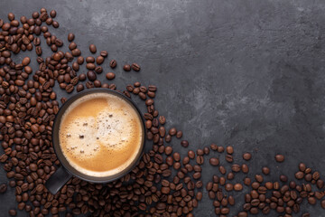 Cups of coffee and coffee beans on dark stone background. Top view. Copy space