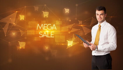 Businessman with shopping cart icons and MEGA SALE inscription, online shopping concept